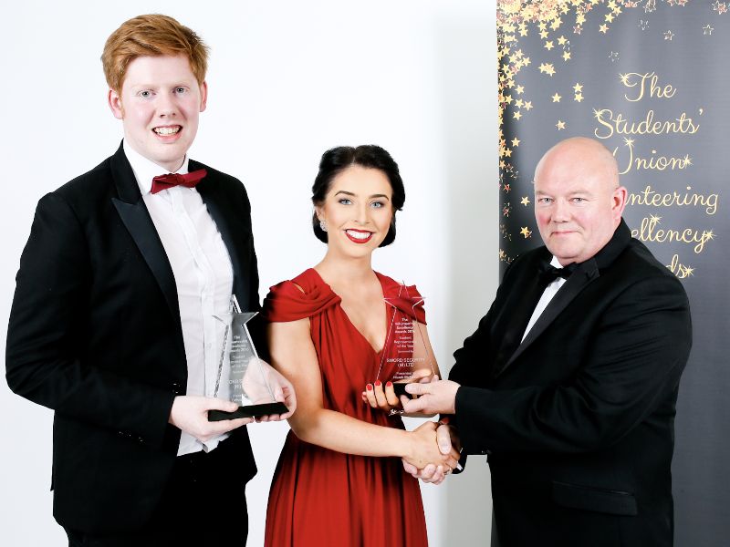 Niamh McErlean and Odhrán Devlin both being presented with the Student Representative of the Year Award by Joe Robson, Sword Security.